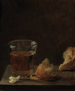 Et glas øl og en rundstykke på et bord