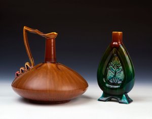 En Linthorpe keramikkande i komprimeret kugleform med stribet karamel, grøn og karminrød glasur og en Linthorpe keramikvase med gennembrudt blomsterknoppynt og plettet grønne, blå og brune glasurer af Christopher Dresser