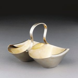 En hvid metalkurv af Christopher Dresser