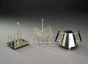 Toaststativ med opretstående understøtninger, fremstillet af Hukin & Heath, 1878 (se 46533 for detaljer); toaststativ i trekantet sektion, fremstillet af Elkington & Co., ca. 1875-88; sukkerskål med eboniseret træ h