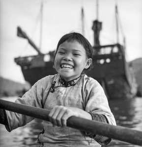 Et portræt af en ung pige i en sampan i Aberdeen havn, Hong Kong.