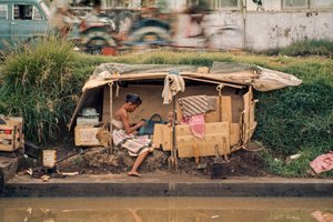 En paphytte langs en spildevandskanal fungerer som hjem. Jakarta, Indonesien.