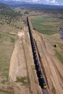 Et kilometerlangt enhedstog fra Atchison, Topeka, Santa Fe-linjen buldrer. Det nordlige New Mexico.