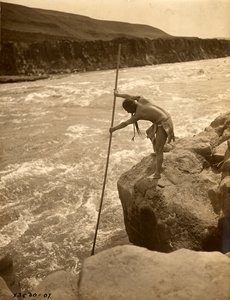 Tlakluit-indianer, stående på klippe, fisker med dykkernet, ca. 1910 (s/h-foto) af Edward Sheriff Curtis