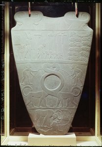 Narmer-paletten: ceremoniel palette, der forestiller kong Narmer, der bærer Nedre Egyptens røde krone, inspicerer bundne og halshuggede fanger, også et par gigantiske, langhalsede katte, fundet ved Hieraco
