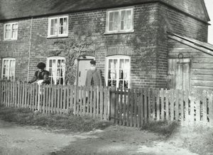 En landlig scene i Wandsworth-området med et ældre ægtepar i haven til en ejendom i hyttestil, London, 1895 af English Photographer
