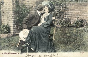 Mand snupper et kys fra en pige på en havebænk (farvefoto) af English Photographer