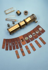 Projektionsmikroskop, forhandlet af Watkins & Hill, London, beregnet til brug med en magisk lanterne, sammen med 18 naturhistoriske dias, ca. 1870 (messing, glas og træ)