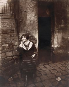 La Villette. Rue Asselin, prostitueret, der venter foran hendes dør af Eugène Atget