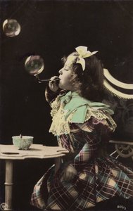 En lille pige blæser bobler fra et rør (tonet billede) af French Photographer