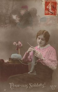 En ung kvinde strikker, mens hun tænker på sin soldat, der skriver et brev hjem (tonet billede) af French Photographer