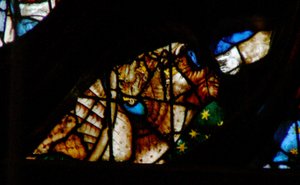 Vinduet med vestrosen viser en scene fra Åbenbaringens Bog: drage med syv hoveder og ti horn og en tredje del af stjernerne (12:3 4). af French School