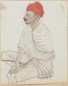 Mand med en rød turban sidder med korsben