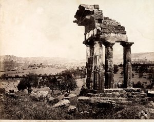 Udsigt over de resterende fire søjler, der understøtter en entablatur af Castor- og Pollux-templet i Valle dei Templi, Agrigento. Et panorama af byen er synligt i baggrunden af Giorgio Sommer