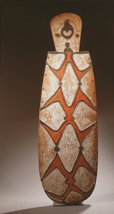 Ovalt Asmat-skjold, udskåret i relief med stiliserede figurer, en maske øverst (træ) af Guinean New