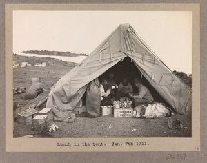 Fire ekspeditionsmedlemmer spiser frokost i et telt af Herbert Ponting