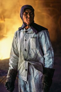 Kinesisk mandlig stålarbejder i beskyttelsestøj på et stålværk i Kina