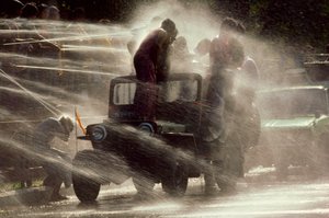 Folk bliver sprøjtet til vandfestivalen under det buddhistiske nytår. Mandalay, Burma. af James L Stanfield