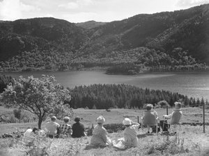Gruppe af mennesker, der sidder på græs eller i liggestole og kigger på udsigten over Thirlmere af Joseph Hardman