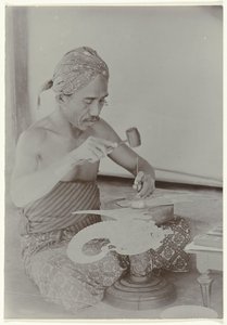 Javanesisk mand bruger hammer og instrumenter til at skabe et billede, der ligner en menneskelig figur