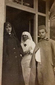 Album af Første Verdenskrig i Friuli-Venezia Giulia: Portræt af to Røde Kors-sygeplejersker med en østrigsk kadetfange i Villa Brazzà, hjemsted for 17 på krigshospitalet i Soleschiano Manzano (s/h-foto) af L. Verdiani