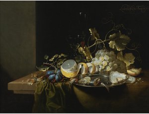 Stilleben med hasselnødder, druer, østers og andre fødevarer på et draperet bord