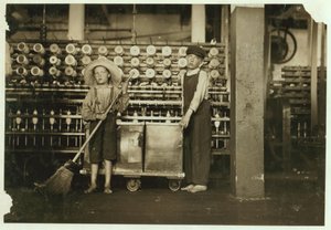 12-årige doffer Ronald Webb og 7-årige Frank Robinson, søn af cardroom boss, som fejer og fjerner (rydder hele spoler) ved Roanoke Cotton Mills, Virginia, 1911 af Lewis Wickes Hine
