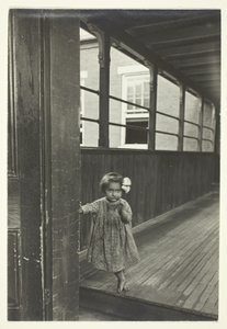 Lille pige står ved indgangen til et galleri af Lewis Wickes Hine