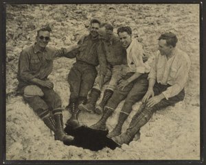 [Gruppebillede af personer siddende ved indgangen til en lodret hule, San Jacinto Peak] af Louis Fleckenstein