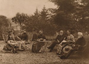 En gruppe mænd og kvinder sad og talte ved et bord, 1937