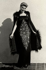 Model i aftenkjole skabt af couture-huset "Graldi". Artiklen er kendetegnet ved rigt broderi og er afsluttet med en pels-trimmet kappe. (s/h foto) af Luis Bogino