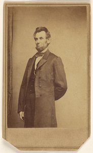 [Abraham Lincoln står med den ene arm bag ryggen]