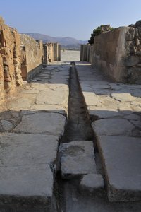 Det minoiske arkæologiske sted Phaistos. Bred korridor med en drænkanal bag porten til den nordlige fløj, der åbner den centrale domstol og fører til en indre gård ved siden af de kongelige lejligheder. Phaistos, Kreta. af Minoan