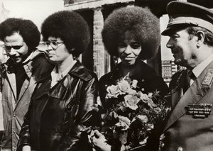 Den 11. september 1972 blev den modige amerikanske kommunist og borgerrettighedsforkæmper Angela Davis hilst hjerteligt velkommen af soldaterne fra Den Tyske Demokratiske Republiks Nationale Folkehær ved Brandenburger Tor (s/h foto) af Photographer German