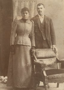 Fotografi af et afroamerikansk par, der står bag en stol, ca. 1890. af Schmitz Studio