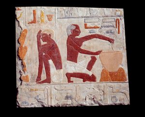 Gammel egyptisk kunst: bagning af brød. En mand laver kagepasta, en anden overvåger bagningen af brødforme. Kalksten (2500-2350 f.Kr.) 5. dynasti. Paris, Musée du Louvre
