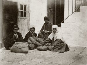Kvinder maler mel med runde møllesten i en gårdhave til et hus i Jerusalem, 1867
