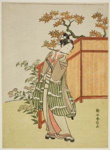 Ung mand spiller på fløjte ved siden af et hegn af Suzuki Harunobu