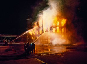 En bybygning helt opslugt af ild og flammer om natten i Kansas City med brandmænd af Ted Spiegel