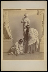 [To mandlige studerende i græsk kostume foran en gipsafstøbning af Afrodite i afstøbningsrummet på Pennsylvania Academy]. af Thomas Eakins
