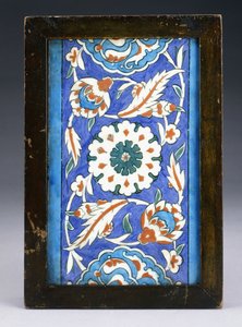 En Iznik-kantflise med et centralt blomsterhoved mellem rullepalmet og grøn vin, ca. 1570 (keramik) af Turkish School