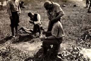 Østrigske fanger under Første Verdenskrig i Bagnaria Arsa, Udine, Italien; i forgrunden barberer en soldat en medsoldat, 02/04/1916 (s/h foto)