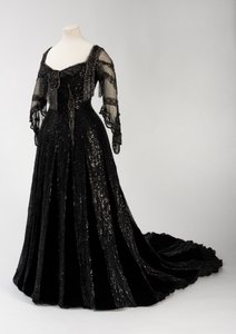Sort aftenkjole i fuld længde båret af dronning Alexandra, med dekoration af perler og pailletter og inkorporeret dronning Alexandras signaturnavnebånd i sort silke og guld, lavet af Barolet fra Knightsbridge, London 1908-1910 (silke og fløjl) af Unbekannt