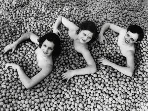 Tre unge kvinder bader i et hav af valnødder. Amerika. 1932 af Unbekannt