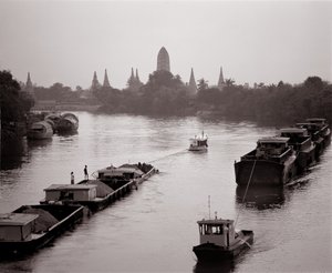 Flodpramme, der kommer ned på Chao Phraya-floden med udsigt over Wat Chaiwatthanaram af Unbekannt