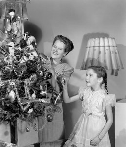 Kvinde og pige pynter et juletræ, c 1948 af Unbekannt