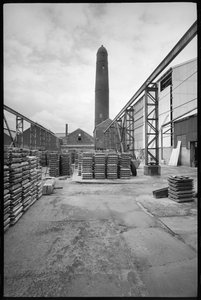En generel visning af Elswick Shot Tower, revet 1968-69, brugt til at skabe blyhagler, med en gård med paletter i forgrunden, ca. 1955-69 (s/h foto) af Unbekannter Künstler
