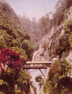 Overdækket bro i en stejl kløft med vandfald i baggrunden, Japan, ca. 1890-1910 af Unbekannt