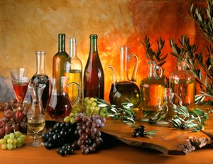 Kost: stilleben med vinkarafler, drueklaser, olieflasker og oliven. af William M. Timlin