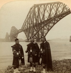 Mænd i Highland klæder sig foran Forth Bridge, Skotland. af Underwood and Underwood